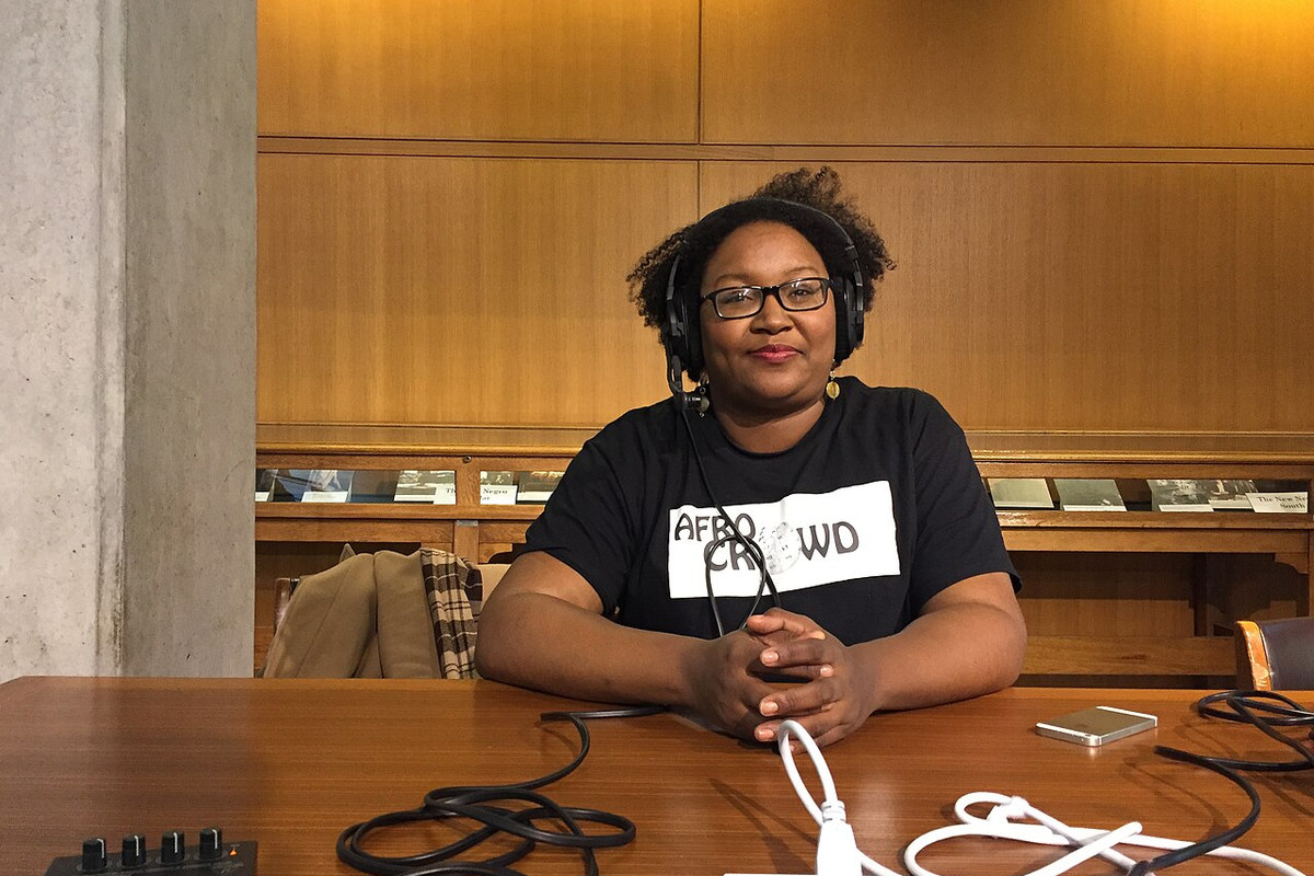 Una presentadora grabando un podcast con audífonos cerrados y micrófono